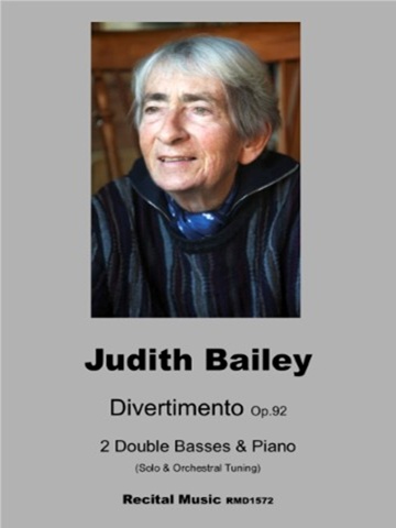 Divertimento Op.92 1 Photograph of composer Judith Bailey on a music book titled Divertimento Op. 92 2 Double Basses & Piano (Solo & Orchestral Tuning) Recital Music RMD1572. The background colour is grey.