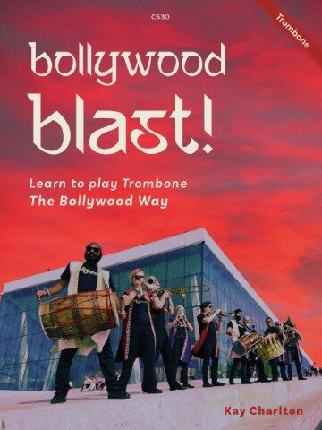 A book cover titled "Bollywood Blast! Learn to play Trombone The Bollywood Way" by Kay Charlton, featuring a group of musicians, including a dhol player and brass band members, in front of a modern building with a vibrant red and orange sky in the background.