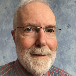 Colour photgraph of composer Stewart Green. He is wearing glasses and has a grey beard.