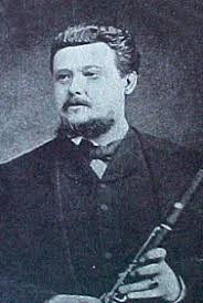 Black ans white image of French composer Jules Demersseman holding a wooden flute or clarinet.