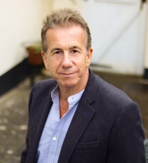 Colour photograph of composer Mark Tanner wearing a blue shirt and dark jacket
