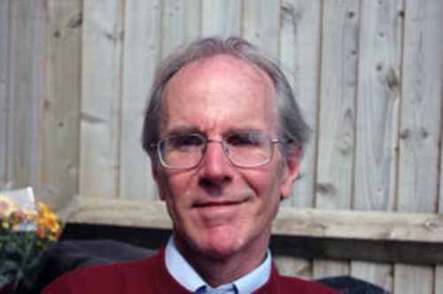 Photo of the composer Richard Benger , probably in his garden as there is a grey fence behind him