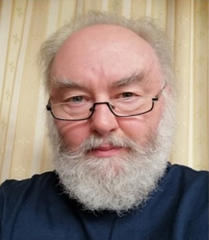 Colour photograpjh of composer Wolfgang Wagenhäuser wearing his glasses and with a white beard.