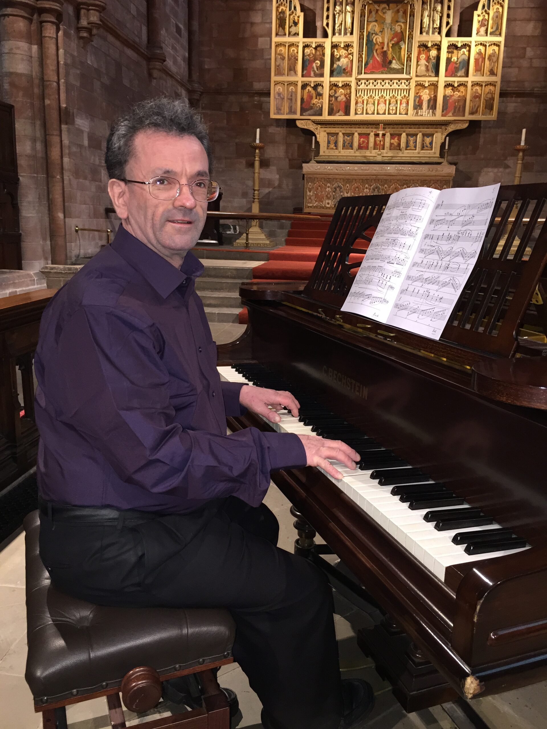Photograph of composer Derry Bertenshaw playing a piano.