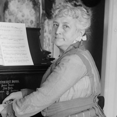 Portrait in black and white of female Venezuelan composer Teresa Carreno playing the piano.