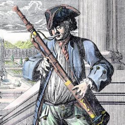 A historical illustration depicts a man, possibly Antoine Dard, in 18th-century attire, wearing a tricorn hat and a long coat, holding a bassoon. The man is shown against a backdrop that suggests an outdoor setting. The illustration is attributed to Johann Christoph Weigel, a German engraver and publisher known for his detailed works depicting various crafts and professions, notably his "Musicalisches Theatrum" series. This series aimed to illustrate musical instruments and the musicians who played them, offering a glimpse into the musical life of the time.