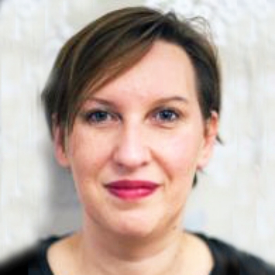 Photograph of composer Hlene Madden. She has short dark hair and red lipstick.