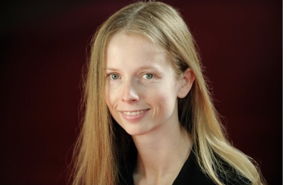 Colour photograph of Canadian female composer Christine Donkin against a dark background.