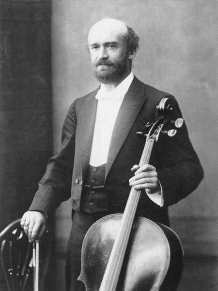 Blacl and white image of composer Julius Klengel, stood upright and holding his cello.